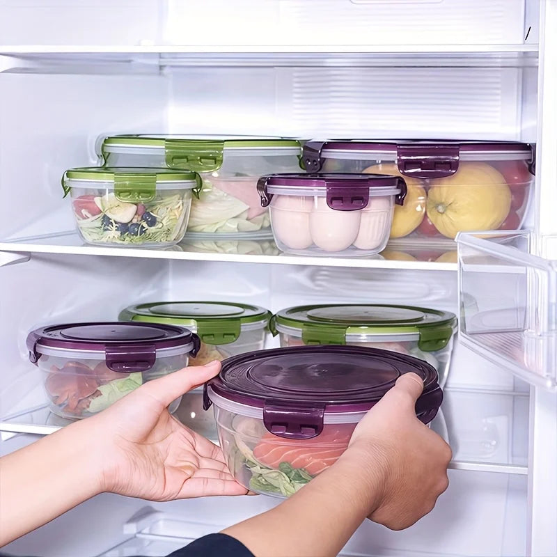 A hand is opening an airtight food storage container filled with greens and pink food in a refrigerator shelf.