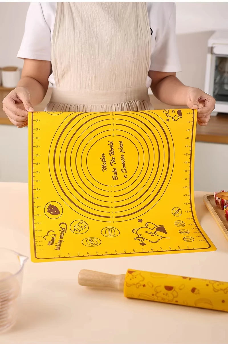 A yellow silicone rolling pin and baking mat set with circular designs is shown on a light surface.