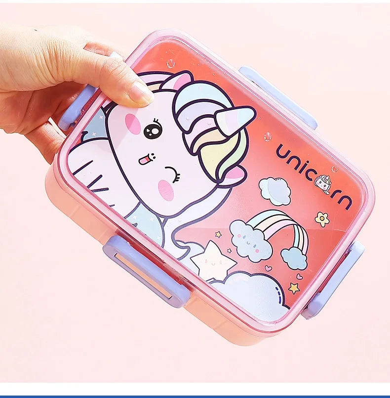 A pink kids bento lunch box featuring a unicorn design with a rainbow and clouds.