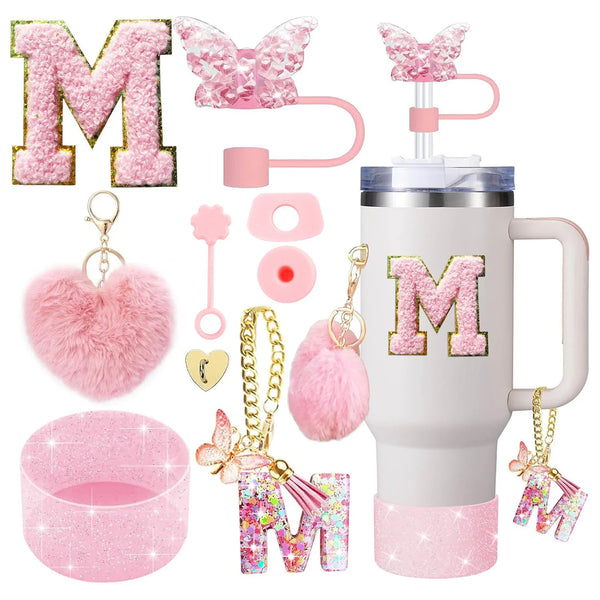 A pink tumbler accessory kit featuring a silicone boot, straw covers, and letter charms for personalization.