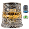 A rotating crystal whiskey glass set featuring a textured glass, a decorative coaster, and an LED light component.