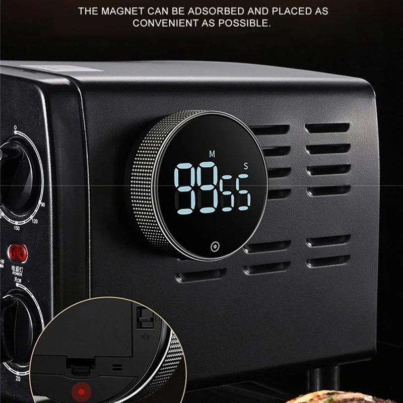 Close-up of a black magnetic kitchen timer with a digital display showing 98.55 seconds.