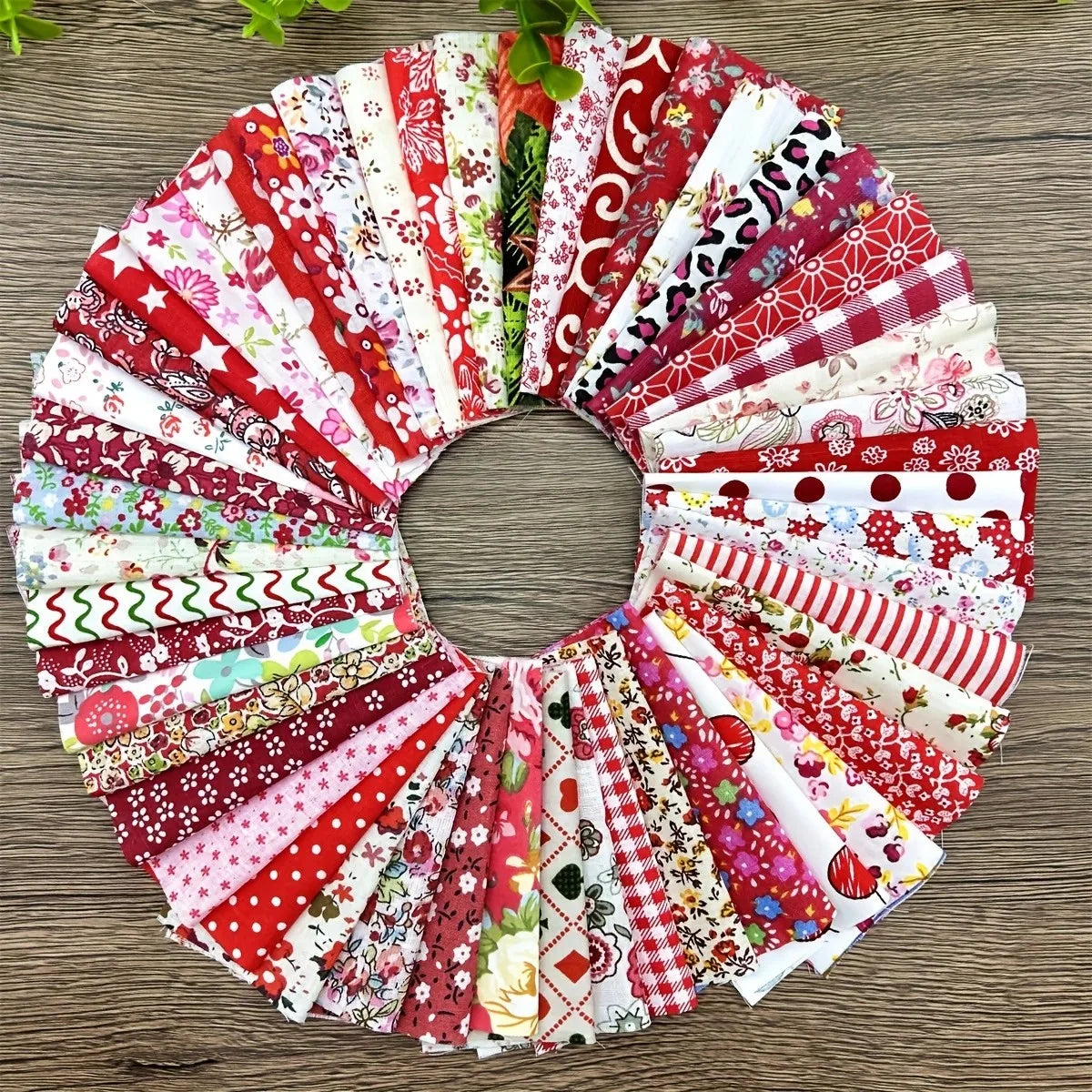 A circular arrangement of square printed cotton fabric packs in various red, pink, and white patterns.