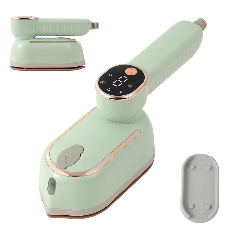 A light mint green foldable handheld garment steamer with a black control dial and a separate nozzle attachment.