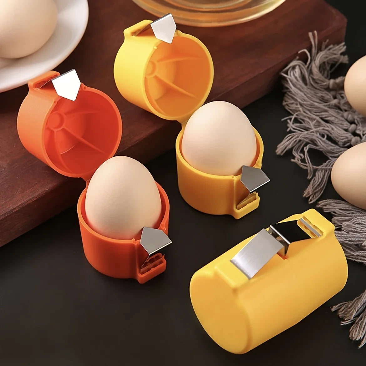 A set of portable yellow and orange egg crackers used for separating or cracking eggs.