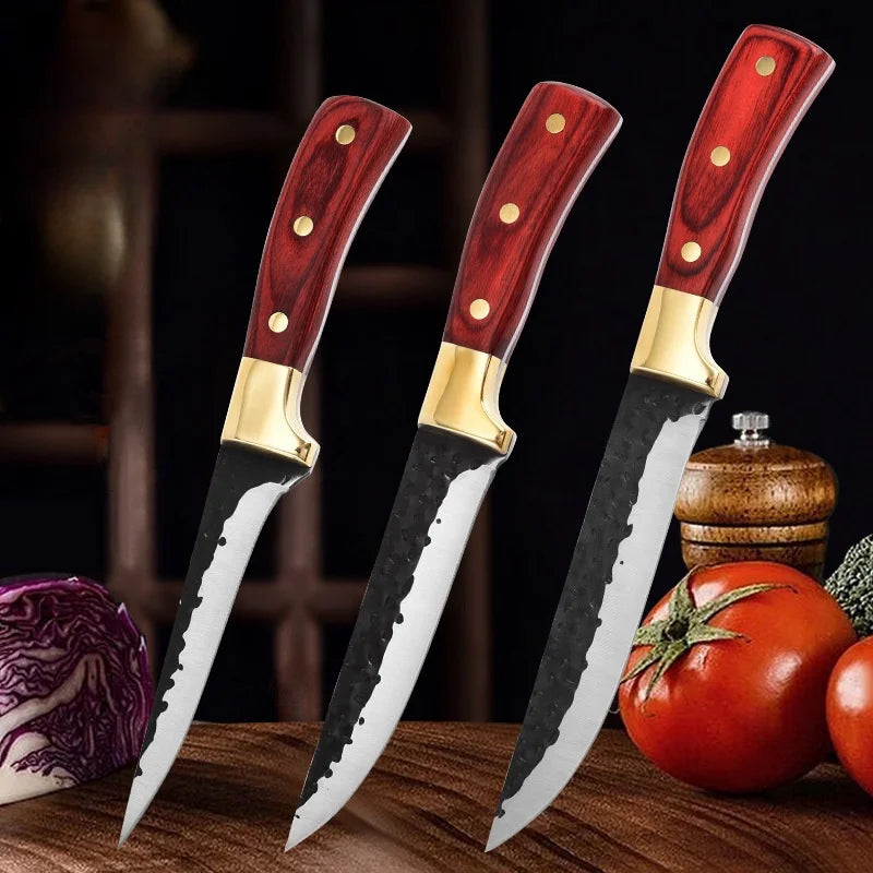 A set of three forged boning knives with wooden handles and stainless steel blades displayed on a wooden surface.