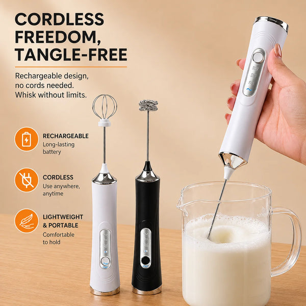 A hand holds a white cordless electric milk frother with a whisk attachment, preparing milk in a glass pitcher.
