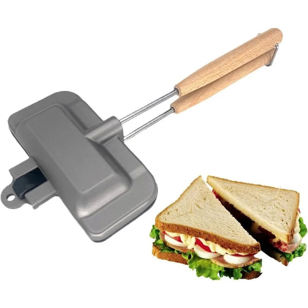 Silberner Sandwichmaker mit Holzgriff neben einem Sandwich