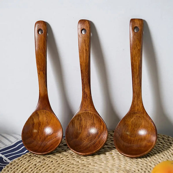 Drei natürliche Holzlöffel zum Kochen auf einer geflochtenen Matte