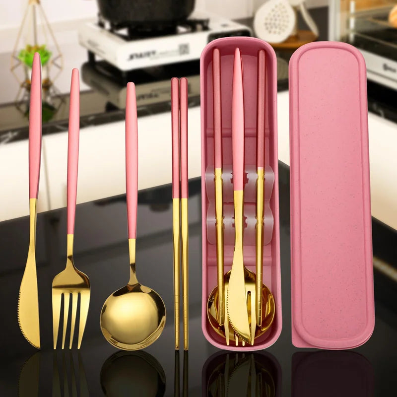 A set of gold and pink stainless steel cutlery with a storage box displayed on a black surface.