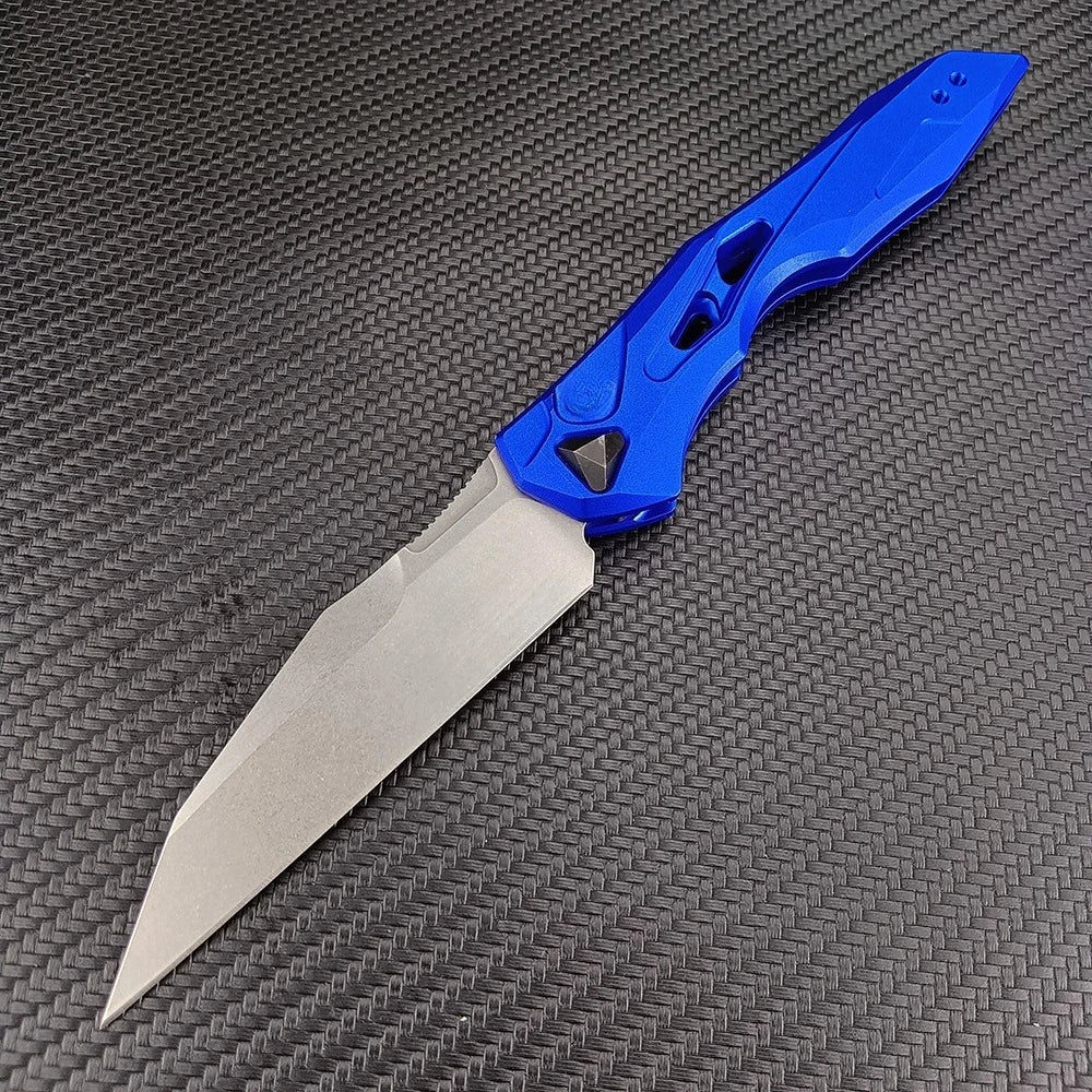 A blue folding blade knife with a silver blade resting on a dark gray textured surface.