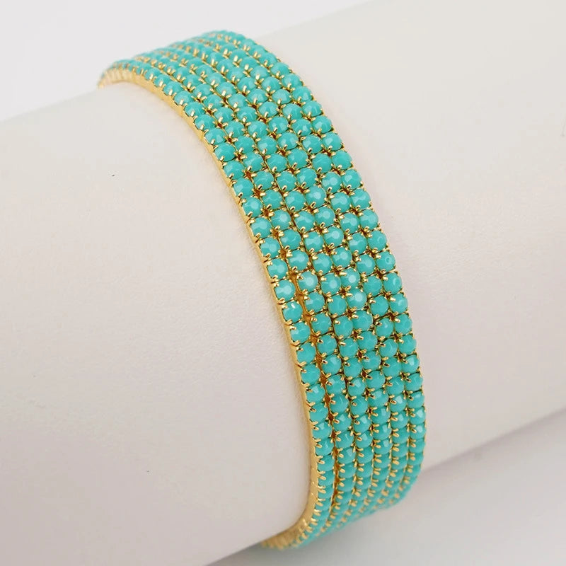 A turquoise beaded elastic bracelet stacked on a white wrist.
