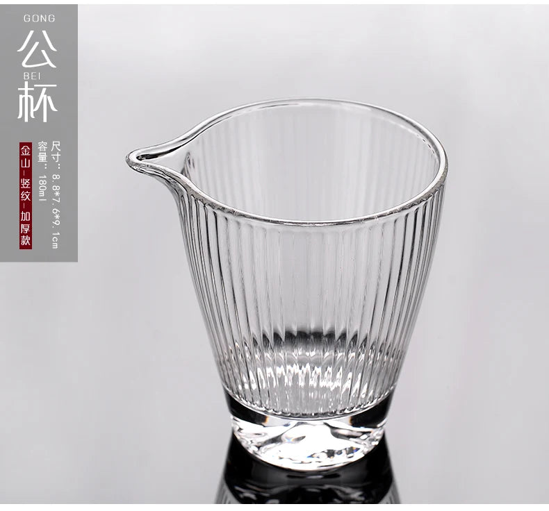 A clear glass teapot or cup with a spout is shown against a white background.