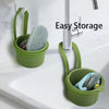 A green press-type drain basket holding a sponge is mounted on a kitchen or bathroom faucet.