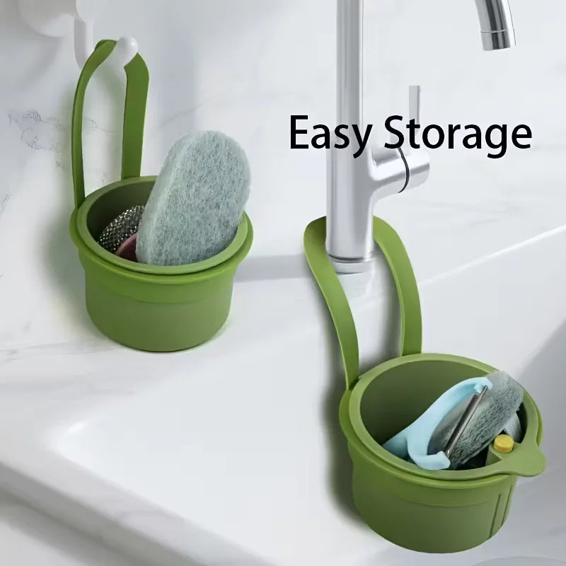 A green press-type drain basket holding a sponge is mounted on a kitchen or bathroom faucet.