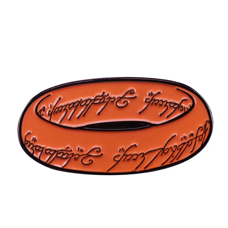 An enamel pin featuring a gold-colored design with black lettering on an orange background.