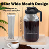 A clear glass pitcher filled with dark coffee, featuring a wide mouth design and a black handle.
