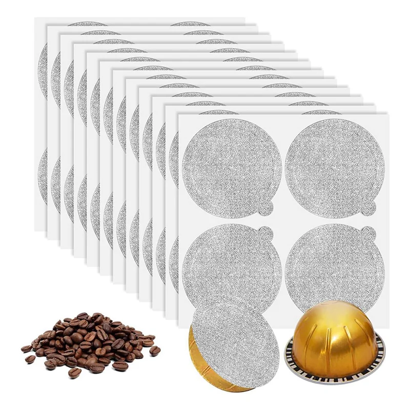 Stapel wiederverwendbarer Aluminiumfolienversiegelungen für Kaffeekapseln, mit losen Kaffeebohnen darunter sichtbar.