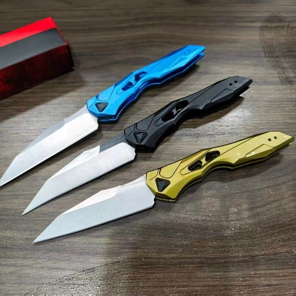 Three folding blade knives in blue, black, and olive green are displayed on a wooden surface.