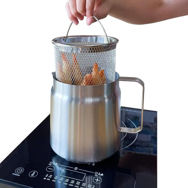Eine Hand hebt einen Edelstahl-Frittiertopf mit einem Drahtkorb voller frittierter Speisen.