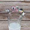 Silicone straw covers with cat-themed designs are shown inserted into a clear glass cup.