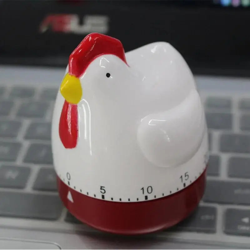 A white ceramic kitchen cooking timer shaped like a duck with a red comb and a red base.