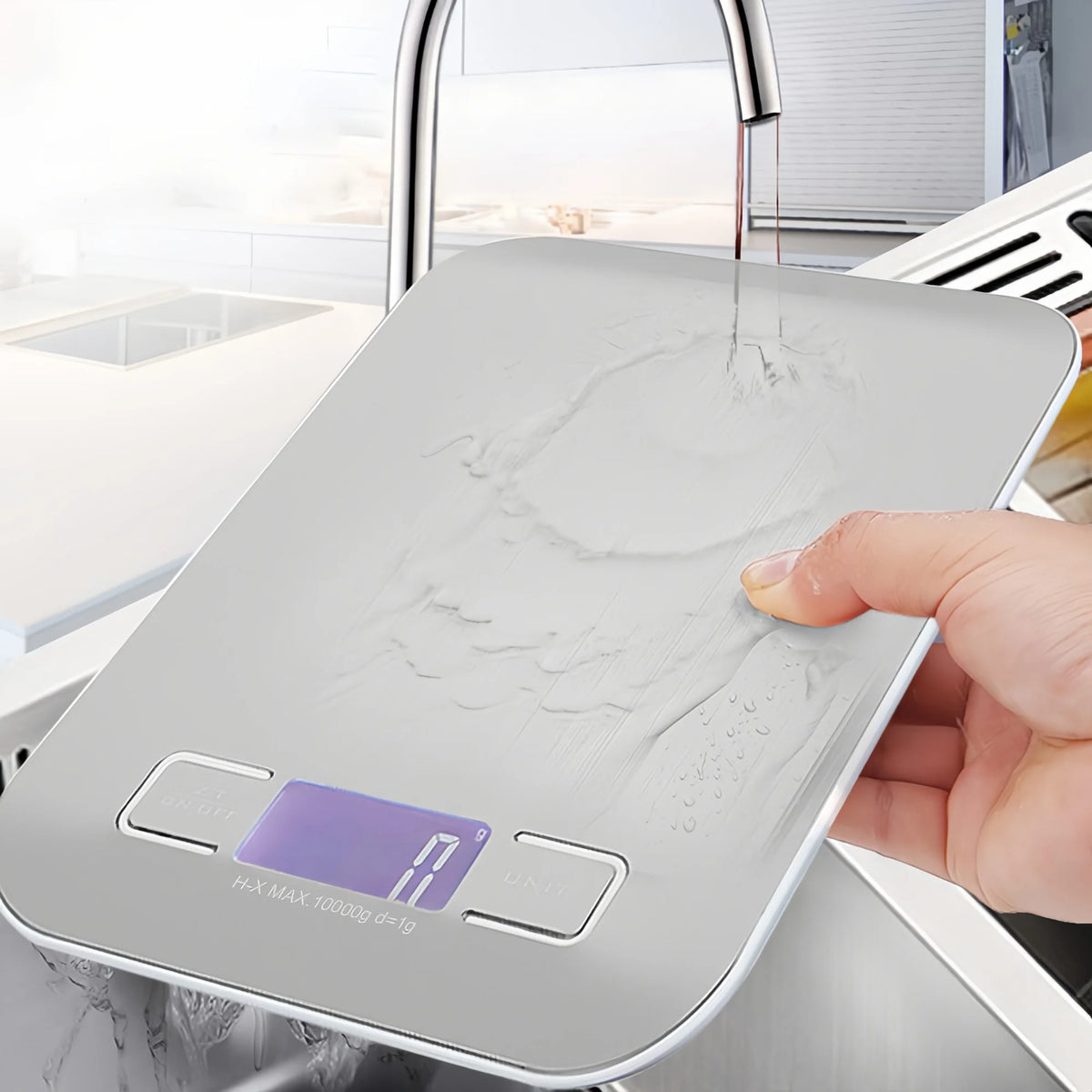 A hand places a silver digital kitchen scale on a countertop, showing the display reading 19 grams.