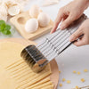 A hand is using a multi-function dough cutter set to cut thin dough sheets, with eggs and a wooden board in the background.