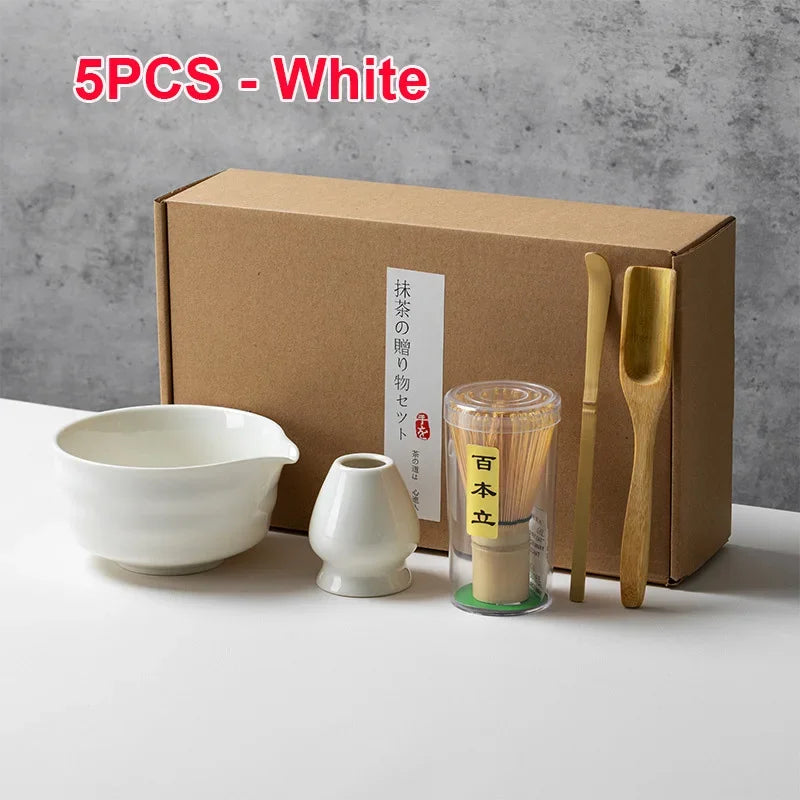 Un juego de cinco herramientas de té matcha blancas, incluyendo un cuenco, un recipiente de cerámica y tres cucharas de bambú