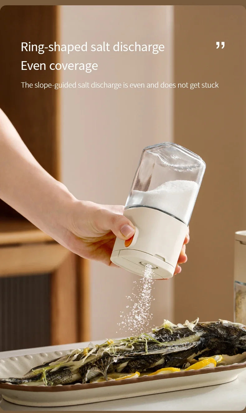 A hand is dispensing salt from a clear glass dispenser bottle onto a plate of fish.