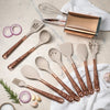 A set of elegant silicone cooking utensils with gold-plated handles arranged on a light surface.
