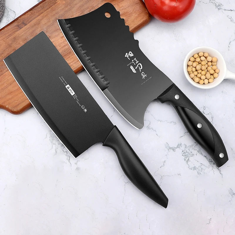A black dual-purpose stainless steel chopping knife rests on a wooden board next to a red tomato and a bowl of chickpeas.