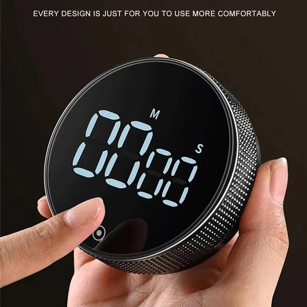 Eine Hand hält einen schwarzen magnetischen Küchentimer mit digitaler Anzeige 00:00.