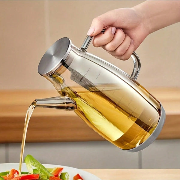 Eine Hand gießt goldenes Öl aus einer Glas-Kraftstoffpumpe auf einen Teller.