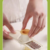 A hand is using a chopstick blade to shred ginger and garlic into fine rice noodles.