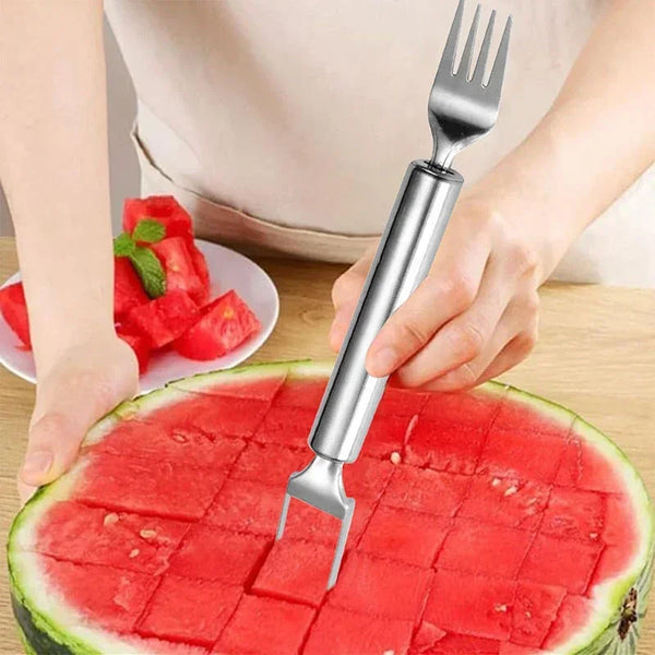 Eine Hand benutzt einen Edelstahl-Obstschneider, um Wassermelone in Würfel zu schneiden.