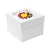 A white square disposable cake box filled with fresh red and yellow berries for a party.