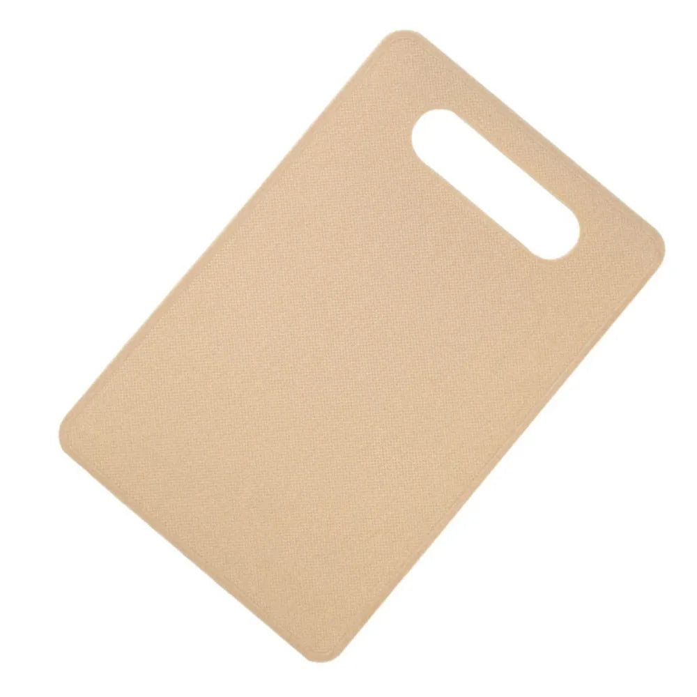 A light beige plastic cutting board with a handle, shown from above.