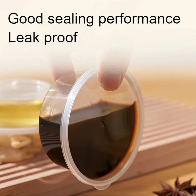 A clear disposable sauce cup is shown being held by a finger, demonstrating good sealing performance.