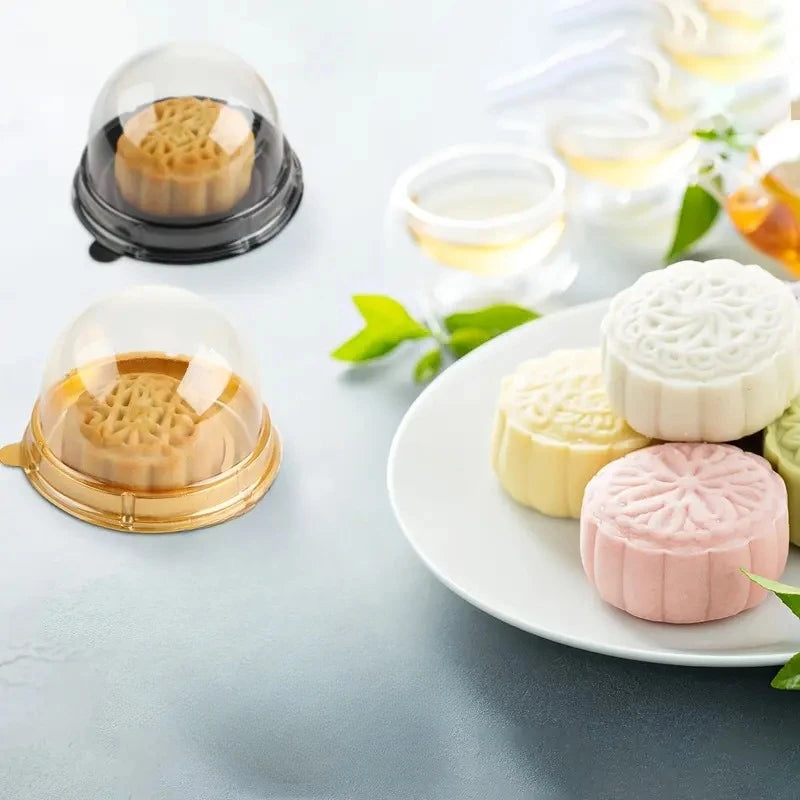 A set of mini transparent cake boxes containing various colored pastries and desserts.