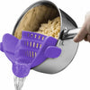 Un colador de clip morado vierte agua desde una olla de acero inoxidable, con pasta seca visible dentro.